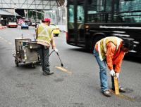 Operai rimuovono strisce gialle dalle strade di Singapore